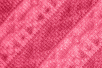 Trendy color of the year 2023. Knitted fabric with pattern, handmade. Background, texture toned in viva magenta color