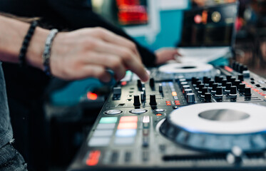 DJ Hands creating and regulating music on dj console mixer in concert