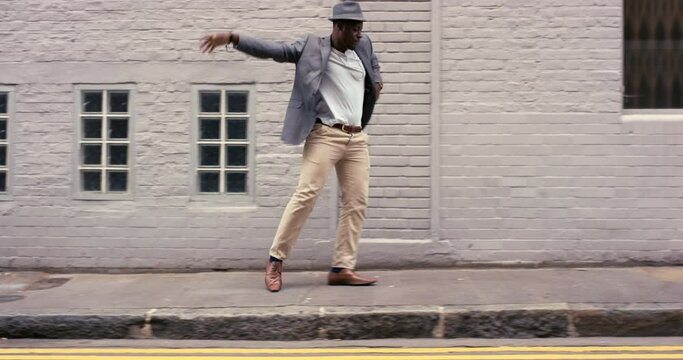 Black man, dancing and in city for excited, freedom and energy. African American male, young guy and dancer with success, happiness and on pavement with dance, wellness and moving in street and relax