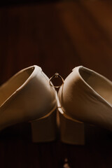 Ring with a stone on white women's leather shoes. Bride's accessories, bride's morning