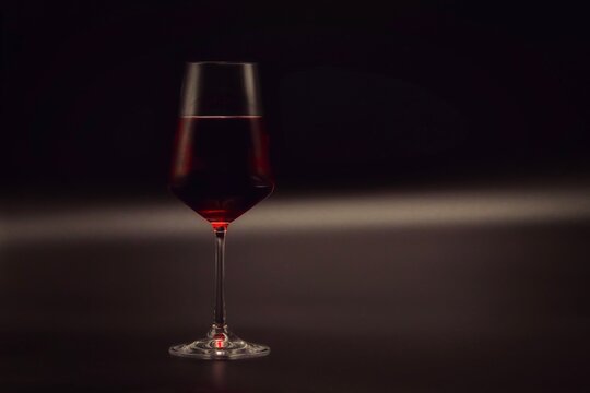Glass of red wine. Grey and black stylish background.