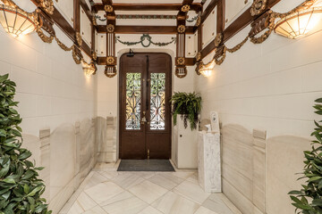 Fototapeta premium Interior of a portal of an old house with white marble floors and a portal with windows and wrought iron