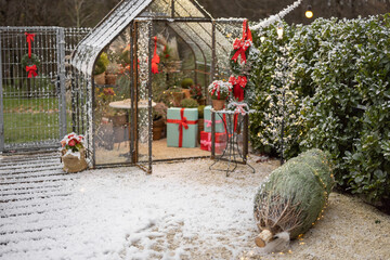 Beautifully decorated backyard with gift boxes, christmas tree and wreaths on winter holidays at...