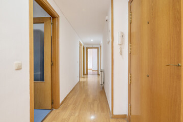 Fototapeta na wymiar Distributor corridor of a house with floating oak flooring, oak doors to access various rooms