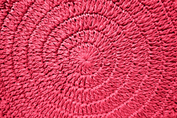 The texture of woven straws in a circle. New 2023 trending PANTONE 18-1750 Viva Magenta color.