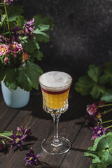 Glass of refreshing THE NEW YORK SOUR cocktail served on dark wooden table surface