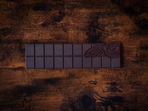 Une tablette de chocolat noir sur un fond de bois