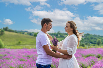 Beautiful purple lavender flowers in a summer field. couple holding hands.