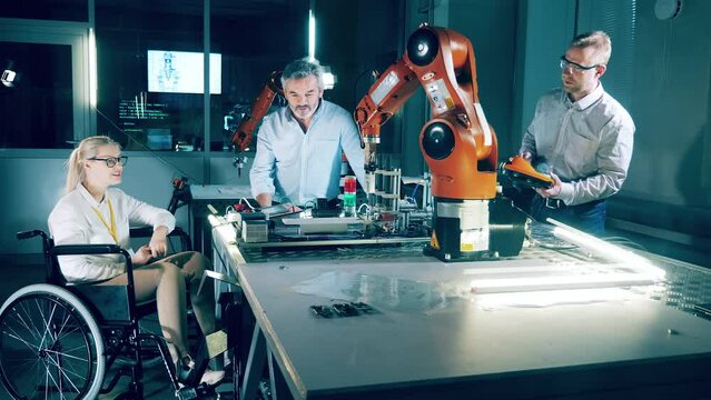 Disability concept, disabled person. Robotics lab with a group of engineers