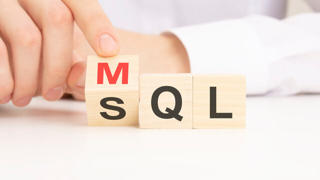 MQL or SQL symbol. Businessman turns cubes and changes words 'MQL marketing qualified lead' to 'SQL sales qualified lead'. Beautiful white background.