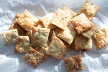 A pile of homemade sourdough crackers with pizza seasonings.