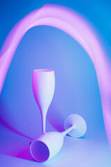 Neon illuminated champagne glasses. New Year celebration futuristic concept. Technology, digital lifestyle.