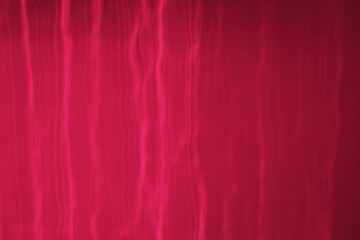 Viva Magenta colour of the 2023 year. The reflection of the sun's rays on the wall. Unusual solar reflections.