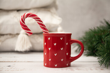 Obraz na płótnie Canvas A cup with New Year's red and white candy, New Year's mood and Christmas tree branches