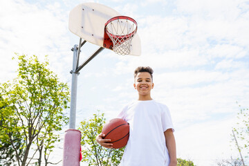 cute Afro american players playing basketball outdoors