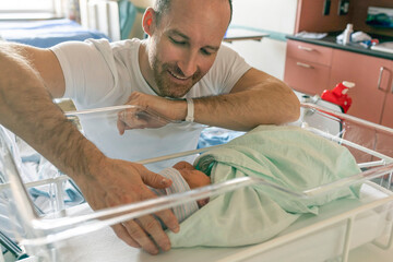 Father with her newborn baby at the hospital a day after birth