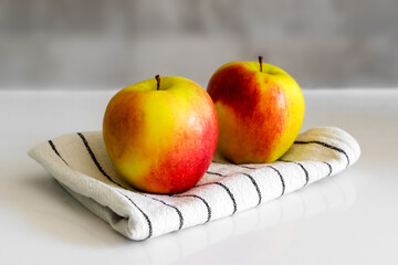 two red-green apples on a light background