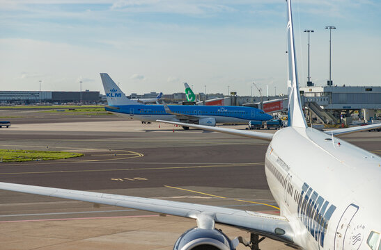 Amsterdam, Netherlands - October 19, 2022: A picture of multiple planes in the Schiphol Airport.