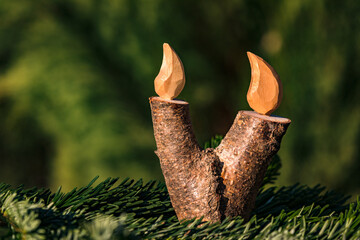 Christmas decorative elements like a candle made of wood against a naturally green background used as greeting card