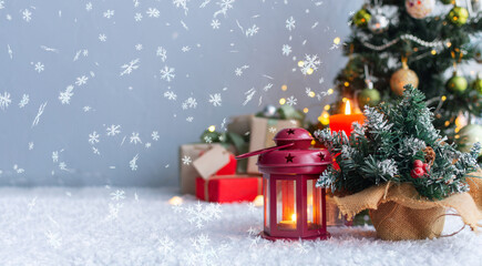 Christmas candles and gift with tags for writing. In the background is a Christmas tree and gifts with lights. New year background.