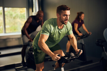 Young man cycling in a gym class
