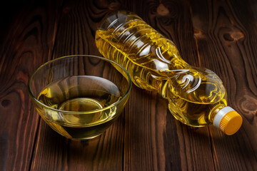 Sunflower oil in bottles with glass bowl on wooden background