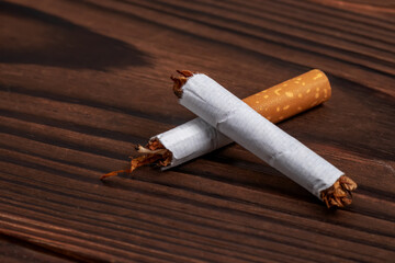 Broken cigarette on wooden background - World No Tobacco Day