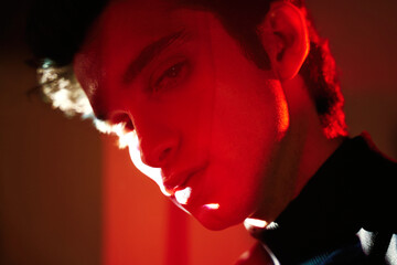 Young man in neon red illumination