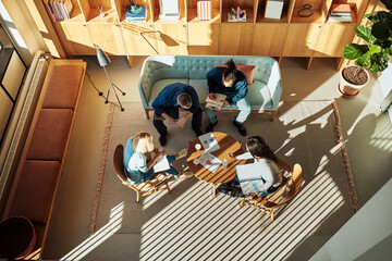 Diverse businesspeople discussing charts during a casual office meeting