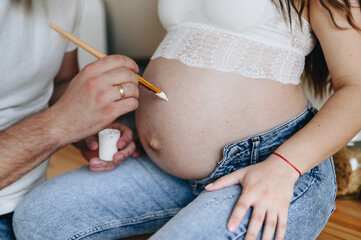 Man draws his pregnant wife stomach. Draws stomach pregnant woman.