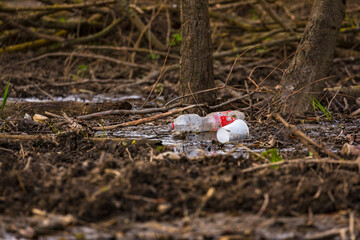 Environmental pollution from a plastic bottle and a plastic cup in nature