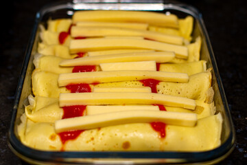 Baked traditional salty pancakes stuffed with ground beef, cheese and sauce
