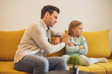 Father feeling feel sorry after conflict with his daughter and he is trying to comfort her.