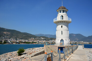 Fototapeta na wymiar white lighthouse in sea port of turkish city Alanya, close-up