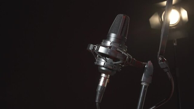 Woman singer connecting cable to microphone in studio for record song. Close up