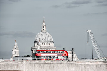 Red double decker bus crossing a bridge in London, England. Black and white photo with red iconic...