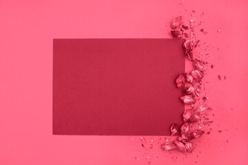 A blank sheet of paper and dried roses on a monochrome background. Top view, space for text. New 2023 trending PANTONE 18-1750 Viva Magenta color.