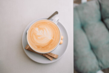 Top view of cup of cappuccino coffee with latte art on gray table in cafe. 