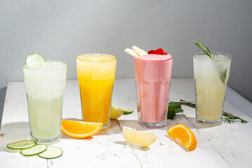 Many different cocktails and milkshakes on a light background. Colored  non-alcoholic cocktails and lemonades in tall glasses