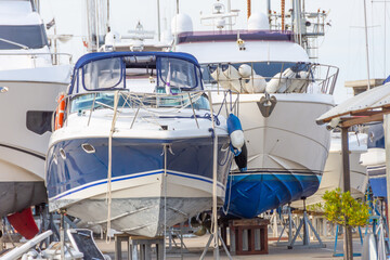 Fototapeta premium Stern nose of sea yachts and boats installed on special supports for storage and maintenance of ships in the docks.