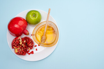 Jewish New Year Rosh Hashanah Traditional blue background with green apple, pomegranate and honey...