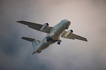 Airplane prepped for landing flying overhead.