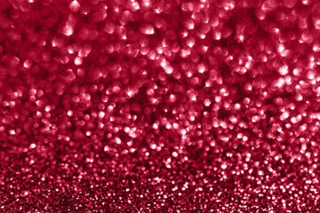Glamour red sparkling background. Blured glitter background with blinking stars. Holiday abstract texture. Demonstrating Viva Magenta - trendy color of the year 2023