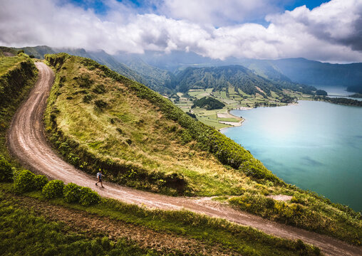 aerial of hiker walking along gravel road, Cete Cidades, Azores