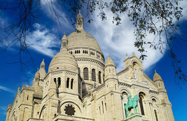 Fototapeta na wymiar Beautiful closeup view on isolated dome of Sacre Coeur church, autumn tree branches, clear blue spectacular sky, fluffy cloud - Paris, France