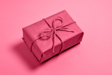 present gift in Color 2023 viva magenta. Demonstrating color of 2023 year viva magenta. eco gift box with twine bow.