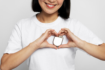 Cropped view of the woman holding Implantable cardioverter defibrillator (ICDs) at white background