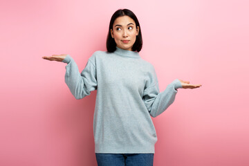 Portrait of uncertain confused girl in sweater expressing doubts and bewilderment