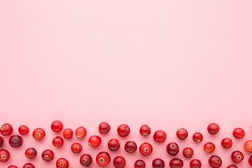 Fresh red cranberries on light pink table background. Pastel color. Closeup. Top down view. Empty place for text.	