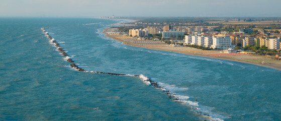 Aerial shot of sandy beach with umbrellas, typical adriatic shore.Summer vacation concept.Lido...